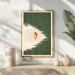 K&ouml;nnte beinhalten: Gerahmter Kunstdruck mit einem orangefarbenen Koi-Fisch, der in einem Teich schwimmt. Das Kunstwerk hat eine japanische &Auml;sthetik mit gr&uuml;nem Wasser und einem cremefarbenen Hintergrund. Der Fisch ist der Mittelpunkt, umgeben von konzentrischen Kreisen.