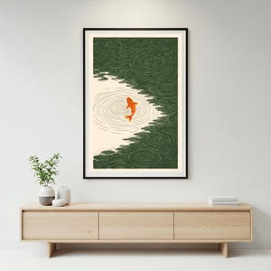 K&ouml;nnte beinhalten: Gerahmter Kunstdruck mit einem orangefarbenen Koi-Fisch, der in einem Teich schwimmt. Das Kunstwerk hat eine japanische &Auml;sthetik mit einer gr&uuml;nen und cremefarbenen Farbpalette. Der Fisch befindet sich in der Mitte des Bildes, umgeben von konzentrischen Kreisen.