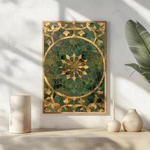 以下が含まれることがあります： 金とエメラルドグリーンのデザインの額入りアートプリント。このアートワークは、複雑な金のディテールと幾何学的な花のモチーフを備えた中央の円形パターンを特徴としています。フレームは暖かく、明るい茶色です。