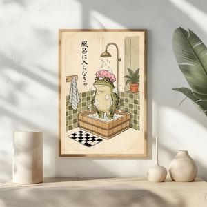 Peut inclure: Illustration encadrée d'une grenouille dans une baignoire en bois sous une douche. La grenouille porte un bonnet de douche rose et est entourée de bulles. Le fond présente un mur carrelé, une serviette et du texte japonais.