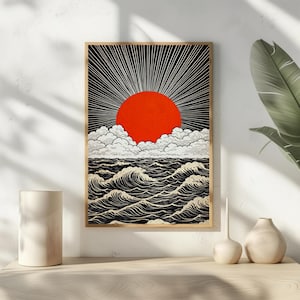 May include: A framed art print featuring a stylized depiction of a sunset over the ocean. The artwork showcases a vibrant red sun radiating light against a black sky, with white clouds and black and white waves.