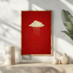 May include: A framed art print featuring a gold cloud with rain droplets against a red background. The artwork has a minimalist style and is displayed on a white wall. The frame is made of wood.