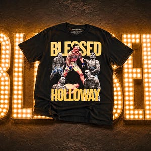 Puede incluir: Camiseta negra con la palabra "BLESSED" en letras amarillas. La camiseta presenta un gráfico de un luchador y la palabra "HOLLOWAY" en amarillo. El fondo tiene letras iluminadas que deletrean "BLESSED".
