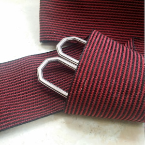 May include: Red and black striped elastic ribbon with silver metal buckle.