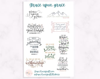 May include: A sheet of stickers with various inspirational quotes in cursive and block lettering. The quotes include "Grace upon grace," "Faith can move mountains," and "Be kind." The stickers are in shades of blue, green, and brown.