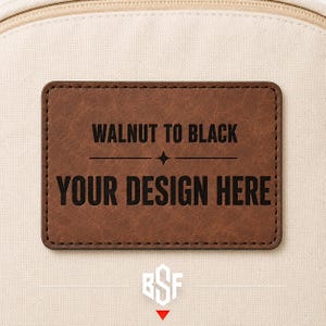 May include: A rectangular brown faux leather patch with rounded corners stitched onto a cream-colored canvas fabric. The patch features black text that reads WALNUT TO BLACK and YOUR DESIGN HERE, separated by a small four-pointed star symbol.