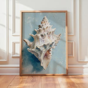 May include: A framed painting of a large, white seashell against a light blue background. The seashell has intricate details and is painted with a textured, brushstroke style. The frame is a light wood color, and the artwork is displayed on a wooden floor.