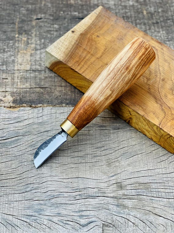 A blacksmith actually forged this skew-blade carving knife from bar stock — walnut handle, brass ferrule, and a working tool that doubles as a desktop art piece.