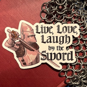 May include: A sticker featuring a knight in silver armor holding a sword. The sticker has the text "Live, Love, Laugh by the Sword" in black. Chainmail is in the background.