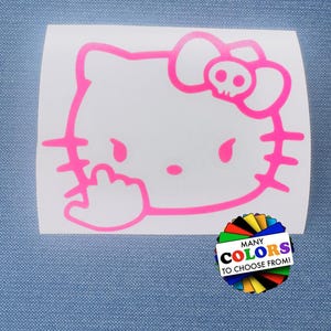 May include: A bright pink vinyl decal featuring a cartoon cat head with a skull on its bow and a hand gesture. The decal includes a circular graphic with the text MANY COLORS TO CHOOSE FROM, showcasing a fan of various colored paper swatches.