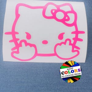 May include: A bright pink vinyl decal featuring the outline of a cartoon cat character with a bow on its head, shown with both hands raised and middle fingers extended. A circular graphic in the corner displays the text MANY COLORS TO CHOOSE FROM.