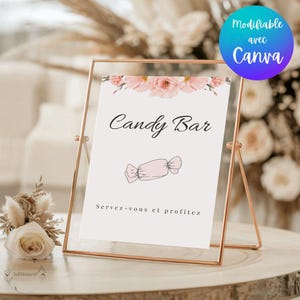 Peut inclure: Un cadre en métal doré rose soutient une pancarte blanche avec "Candy Bar" en écriture élégante. La pancarte présente une illustration de bonbon rose et la phrase "Servez-vous et profitez". Un logo Canva est en haut à droite.