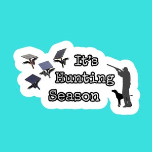 May include: A teal background with a white cloud-shaped border containing the text "It's Hunting Season." Silhouettes of a hunter, dog, and solar-powered bird decoys are also present.