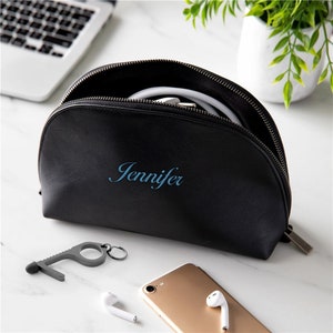 May include: Black zippered travel pouch with the name Jennifer embroidered on the front. The pouch is open and contains a white cord and a silver key chain with a touch tool.
