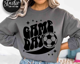 Może przedstawiać: Szara bluza z czarnym nadrukiem graficznym, na którym widnieje napis "GAME DAY" w retro czcionce z piłką nożną. Grafika jest otoczona małymi gwiazdkami.