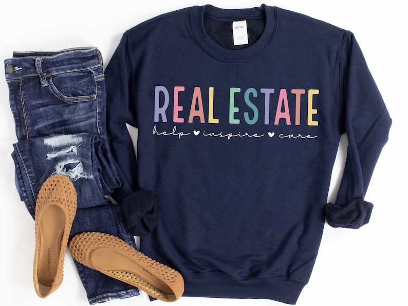 May include: Navy blue sweatshirt with the text "REAL ESTATE help &hearts; inspire &hearts; care" in rainbow colors.