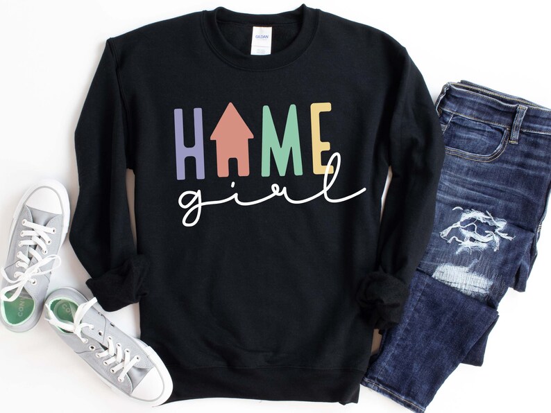 May include: Black sweatshirt with the text "home girl" in colorful letters, including a house icon in the middle of the word "home".