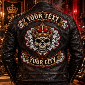 Puede incluir: Una chaqueta de cuero negro con un gran parche bordado en la espalda. El parche muestra una calavera con una corona roja y dorada, rodeada de humo blanco, con el texto "YOUR TEXT" arriba y "YOUR CITY" en la parte inferior.