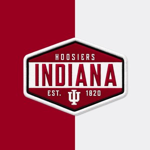 May include: A hexagonal embroidered patch featuring a crimson background with a white horizontal stripe. The text reads HOOSIERS, INDIANA, and EST. 1820, with a white IU trident logo centered below the word INDIANA. The patch has a thick white border.
