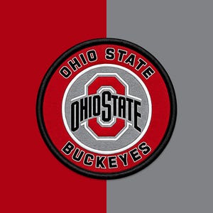 Puede incluir: Un parche bordado circular con el logotipo de los Ohio State Buckeyes. El diseño incluye un fondo rojo con el texto OHIO STATE BUCKEYES en letras blancas, rodeando un logotipo central de una O gris con las palabras OHIO STATE en negro.