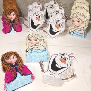 Puede incluir: Colecci&oacute;n de pi&ntilde;atas hechas a mano con personajes de la pel&iacute;cula animada "Frozen". Las pi&ntilde;atas incluyen dise&ntilde;os de Anna, Elsa y Olaf. Cada pi&ntilde;ata tiene una base rectangular y est&aacute; decorada con papel de colores e ilustraciones de personajes.