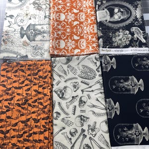 May include: Six folded fabric swatches featuring Halloween-themed patterns. Designs include skulls, skeletons, ravens, pumpkins, and apothecary jars in black, white, and orange. Text on the fabric includes "Boo-tiful" and "RAVEN #makingitfun".