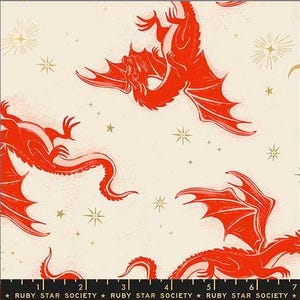 May include: A cream-colored fabric featuring a repeating pattern of bright orange dragons in flight, interspersed with small gold starbursts. A black ruler at the bottom shows measurements in inches, with the text RUBY STAR SOCIETY printed repeatedly.