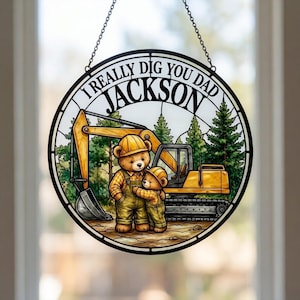 May include: Round stained glass panel with the text "I REALLY DIG YOU DAD JACKSON". The image features two teddy bears in construction outfits hugging in front of an excavator and trees. The panel is suspended by a chain.