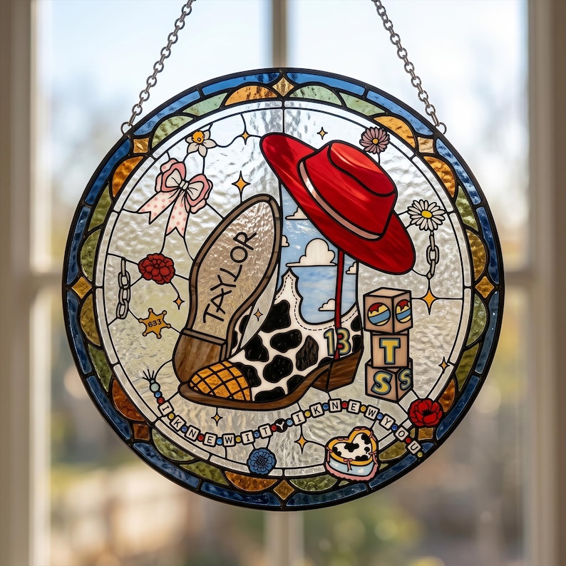 May include: A circular stained glass suncatcher featuring a cow-print cowboy boot with the number 13, a red hat, and stacked blocks with the letters T, S, and S. The text TAYLOR is on the boot sole, and I KNEW YOU is on a beaded string.