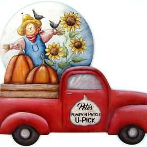 May include: A red vintage pickup truck with a wooden bed filled with pumpkins. A scarecrow with a straw hat and a blue shirt stands on top of the truck bed. The truck has a sign that says "Pete's Pumpkin Patch U-Pick".