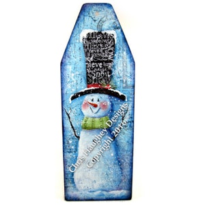 May include: A whimsical snowman painted on a blue background with a black top hat, red scarf, and green scarf. The snowman has a carrot nose and black eyes. The background has a white snow effect and the text "Chris Haughey Designs Copyright 2016".