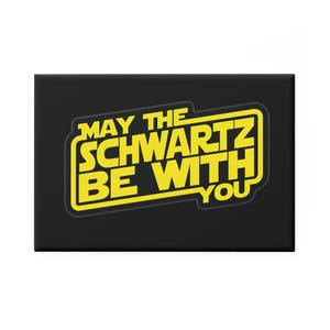 Puede incluir: Un imán rectangular negro con texto amarillo que dice "MAY THE SCHWARTZ BE WITH YOU" en un cuadro amarillo. Un artículo de novedad.