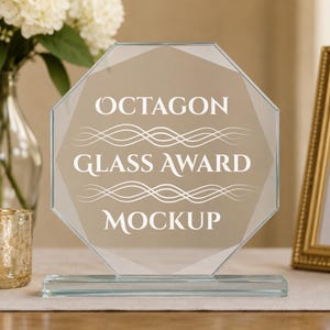 May include: An octagonal clear glass award plaque featuring white text that reads OCTAGON GLASS AWARD MOCKUP, accented by two sets of horizontal wavy lines. The glass piece is mounted on a rectangular clear glass base for stability.