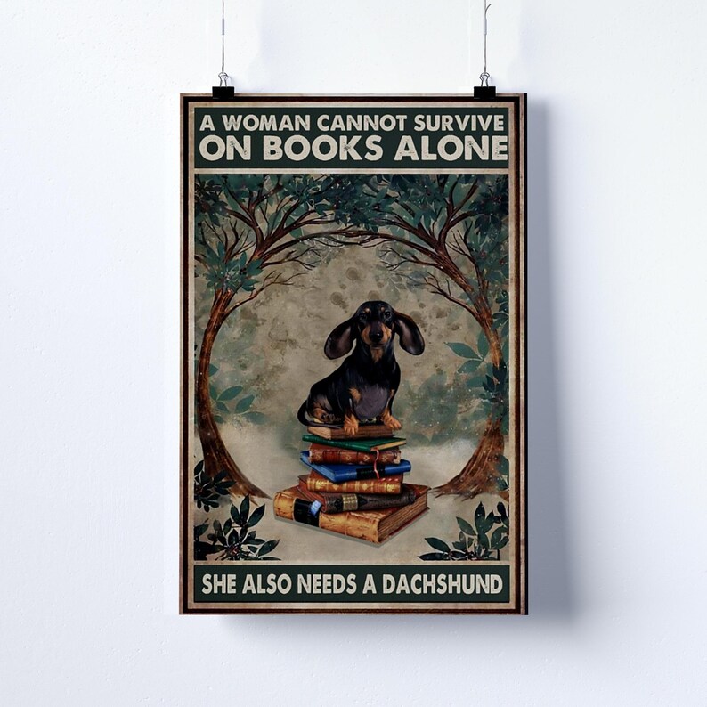 Peut inclure: Affiche encadr&eacute;e avec le texte "A WOMAN CANNOT SURVIVE ON BOOKS ALONE SHE ALSO NEEDS A DACHSHUND." L'affiche pr&eacute;sente un teckel assis sur une pile de livres, avec une sc&egrave;ne de for&ecirc;t en arri&egrave;re-plan.