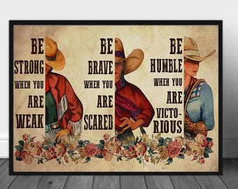 May include: Framed artwork featuring three cowgirls with inspirational text. The text reads "Be Strong When You Are Weak", "Be Brave When You Are Scared", and "Be Humble When You Are Victorious". The artwork is decorated with floral accents.