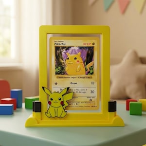 May include: A yellow Pikachu card display frame with a Pikachu card inside. The frame has a Pikachu figure attached to the front. The card features a yellow Pikachu character with the text "Pikachu" and "40 HP".
