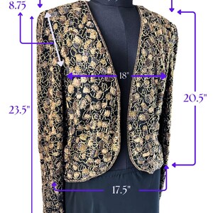 May include: Black and gold sequined jacket with a V-neck design. The jacket is 23.5 inches long, 15.5 inches across the shoulders, and 18 inches across the chest. The sleeves are 8.75 inches long, and the bottom hem is 17.5 inches wide. The jacket's length from shoulder to hem is 20.5 inches.