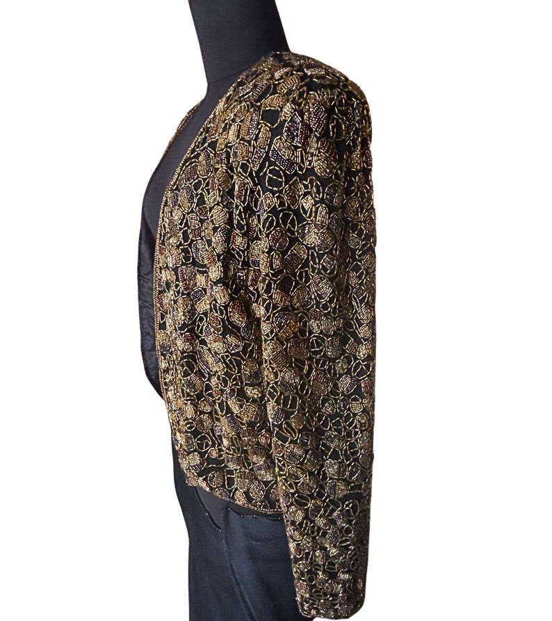 Open front vintage beaded evening jacket on a black mannequin.