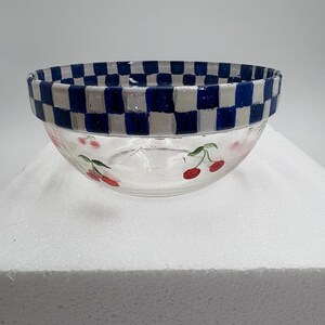 May include: Clear glass bowl with a blue and white chequered rim. The bowl features hand-painted red cherries with green stems around the exterior. A decorative kitchenware item.