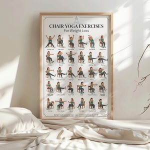 May include: A framed poster titled "Chair Yoga Exercises For Weight Loss" with illustrations of yoga poses performed while seated. The poster features a light wood frame and is displayed on a bed with a white comforter.