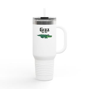 Può includere: Tazza da viaggio bianca con manico e cannuccia. La tazza presenta il testo "Gizz On My" sopra un'illustrazione di un alligatore dei cartoni animati. La tazza ha un coperchio argentato e un manico bianco.