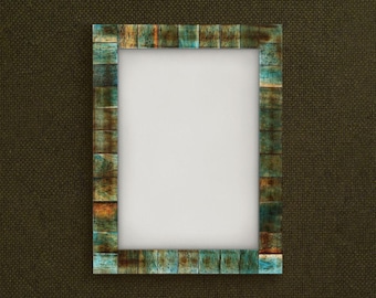Puede incluir: Marco de fotos rectangular con un borde de estilo mosaico. El borde del marco presenta una mezcla de tonos azules, marrones y naranjas, lo que le da un aspecto rústico. El marco tiene un interior blanco, listo para una foto o una obra de arte.