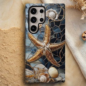 May include: A smartphone case featuring a mosaic design with a starfish, seashells, and a blue and gold color scheme. The case has a multi-camera setup and a black border. The design resembles stained glass.