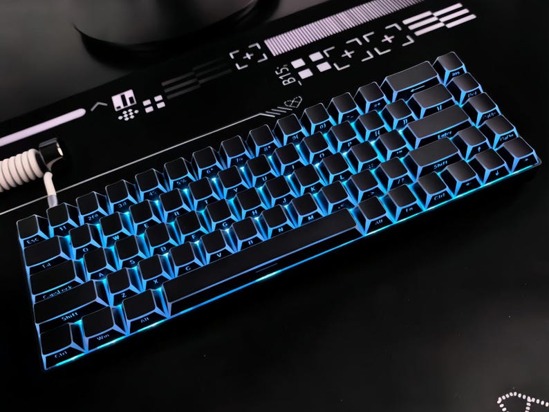 May include: A black mechanical keyboard with blue LED backlighting. The keyboard has a compact design with black keycaps and a sleek, modern aesthetic. The keys are illuminated with a vibrant blue glow. The keyboard is designed for gaming and typing.