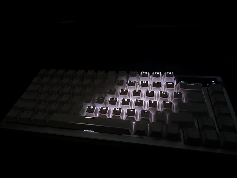 Op de afbeelding: Een mechanisch toetsenbord met verlichte witte toetsen. De toetsen zijn wit en de achtergrondverlichting zorgt voor een heldere gloed tegen de donkere achtergrond. Dit toetsenbord is ontworpen voor gaming of professioneel gebruik.