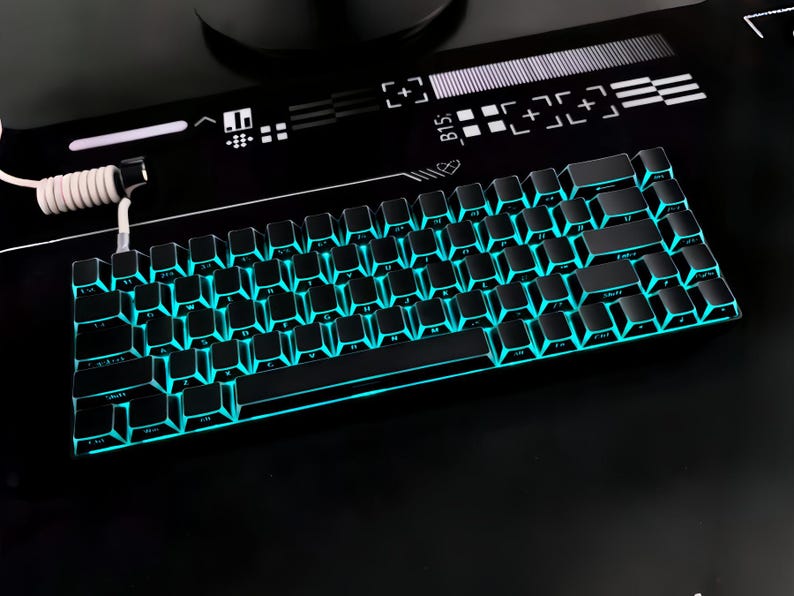 May include: A black mechanical keyboard with teal backlighting. The keyboard is on a black surface with a white and black design. The keys are dark, and the teal light shines through the keycaps.