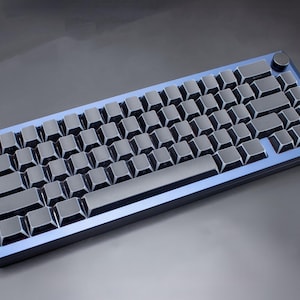 May include: A mechanical keyboard with a blue frame and dark grey keycaps. The keyboard has a compact layout, with a knob in the upper right corner. The keys are arranged in a standard QWERTY layout.