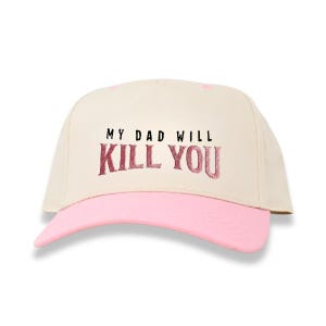 May include: A baseball cap with a cream-colored crown and a pink brim. The text "MY DAD WILL KILL YOU" is printed in dark pink across the front of the cap.