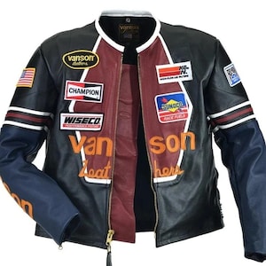 Peut inclure: Veste en cuir noire avec int&eacute;rieur bordeaux et manches bleues. La veste pr&eacute;sente plusieurs &eacute;cussons avec du texte et des logos, dont "Vanson Leathers", "Champion" et "Sunoco Race Fuels". Fermeture &eacute;clair et col blanc.
