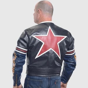 Peut inclure: Veste en cuir noire avec une grande &eacute;toile rouge bord&eacute;e de blanc dans le dos. Les manches sont bleues avec des d&eacute;tails dor&eacute;s et une fermeture &eacute;clair. Des rayures blanches et rouges ornent le haut du bras.